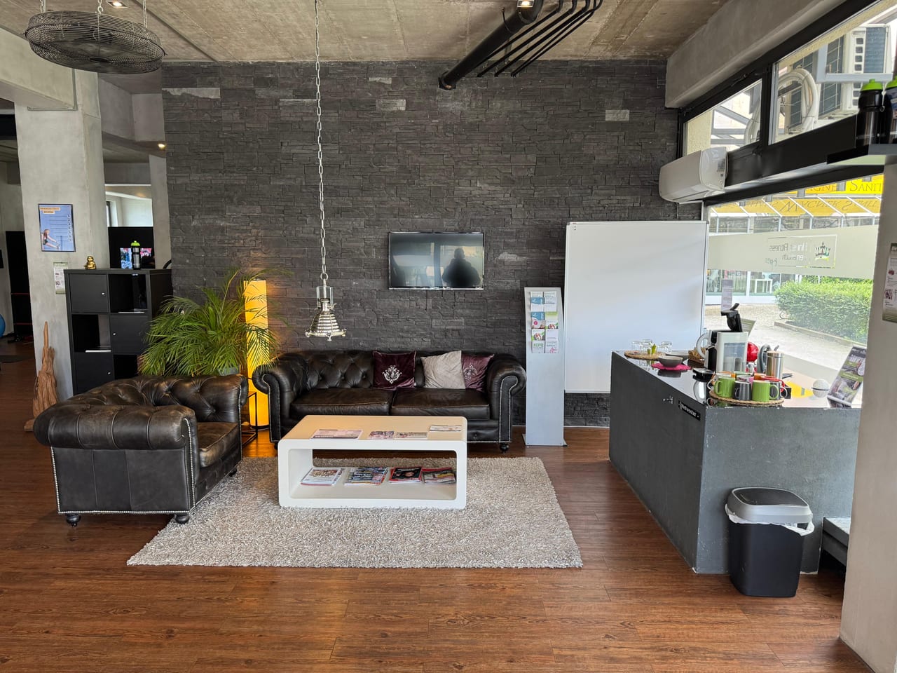 Lounge mit zwei Ledersofas und großen Schaufenstern